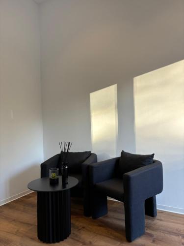 a living room with two chairs and a table at Schwentine Suite in Kiel
