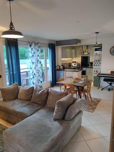un salon avec un canapé et une salle à manger dans l'établissement Pied des montagnes proche du lac d'Annecy, à Évires