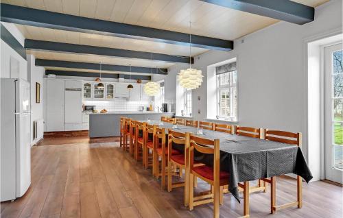 a kitchen and dining room with a table and chairs at Holiday Home Engsvinget Højer X in Vrågård