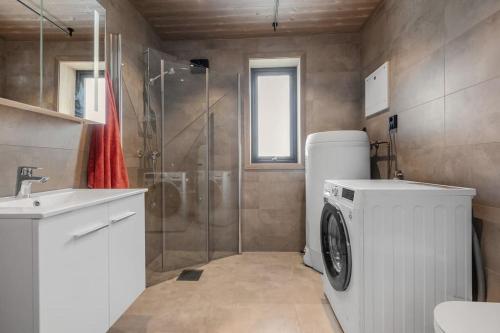 y baño con lavadora y ducha. en Ny moderne hytte i Aust-Torpa, en Aust-Torpa