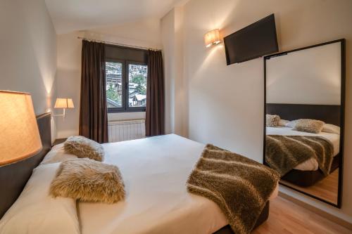 a bedroom with two beds and a large mirror at Apartaments Superior in El Tarter