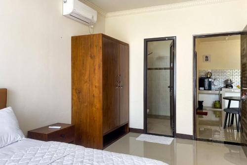 a bedroom with a bed and a wooden cabinet at Salma Syariah by TwoSpaces, Bogor in Jakarta