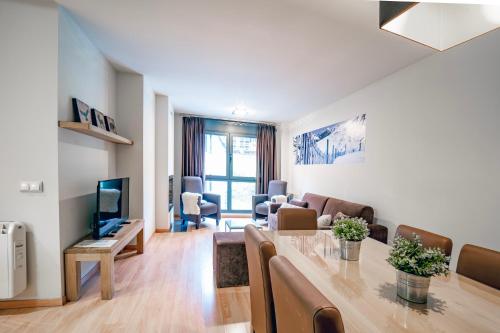 a living room with a table and a couch and a television at Apartaments Superior in El Tarter