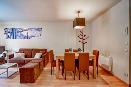 a dining room with a table and a couch at Apartaments Superior in El Tarter