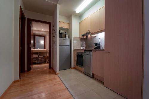 a kitchen with stainless steel appliances and wooden cabinets at Apartaments Superior in El Tarter