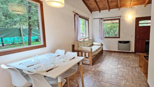 a dining room with a white table and chairs at Casa Moderna entre Coihues in San Carlos de Bariloche
