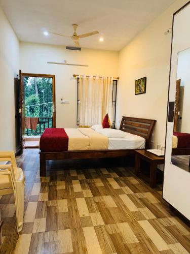 a bedroom with a large bed and a window at Dubare plantation stay in Siddapur