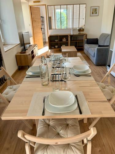 une table en bois avec des assiettes et des verres dans l'établissement Appartement neuf 2 pièces 43m2 