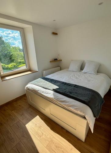 une chambre avec un grand lit avec une fenêtre dans l'établissement Appartement neuf 2 pièces 43m2 