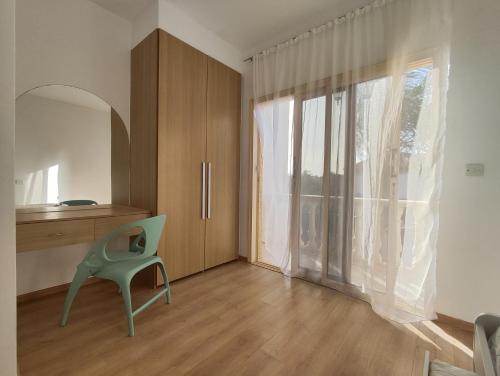 Habitación con silla verde y ventana grande. en 2 bedroom Maissonate in tourist are, en Limassol