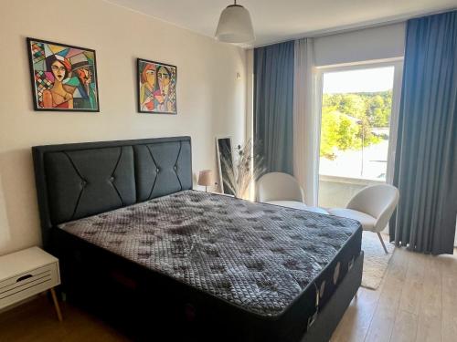 a bedroom with a large black bed in a room at Venus Apartment in Kŭrdzhali