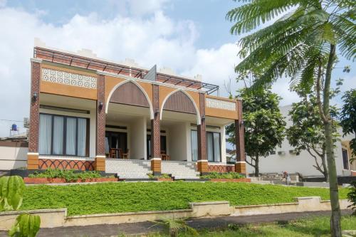 a building with a palm tree in front of it at Salma Syariah by TwoSpaces, Bogor in Jakarta