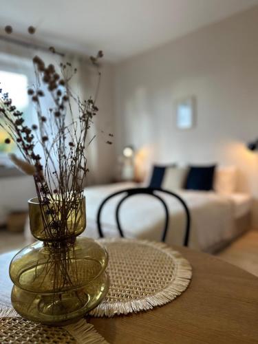 a vase with flowers on a table in a living room at APARTAMENTY LAVENDERIA z widokiem na Górę Parkową, blisko centrum in Kudowa-Zdrój