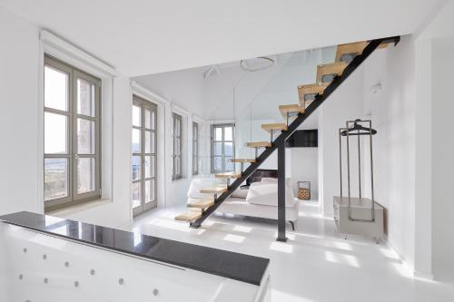 a staircase in a white room with windows at Clock Tower Aparthotel in Arachova