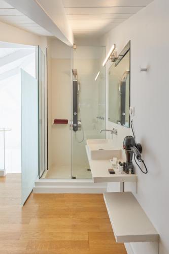 a bathroom with a glass shower and a sink at Clock Tower Aparthotel in Arachova