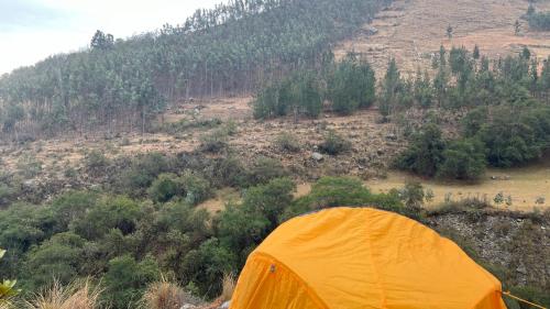 an orange tent sitting on top of a hill at Refugio Ecológico Hanan Pacha Granja, Montañas y Aventura in Huaraz