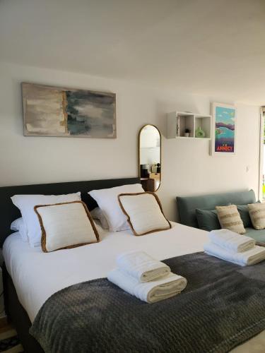 a bedroom with a large white bed with towels on it at Annecy poisy Studio a 9 minutes du lac Annecy avec piscine privée in Poisy