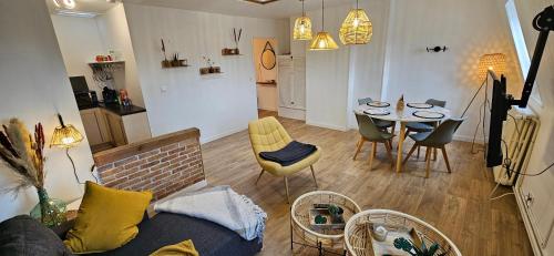un salon avec un canapé, une table et des chaises dans l'établissement Les toits de Dieppe - appartement en plein cœur du centre ville, à Dieppe