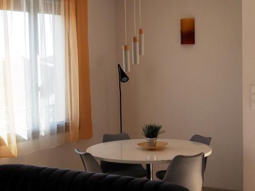 une salle à manger avec une table et des chaises blanches dans l'établissement La maison d'Emile, à Cerbère