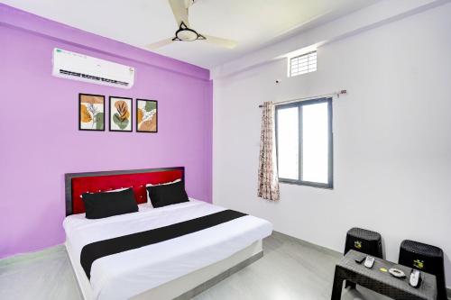 ein Schlafzimmer mit einem Bett mit lila Wänden und einem Fenster in der Unterkunft HOTEL O S S STAY INN in Nagpur