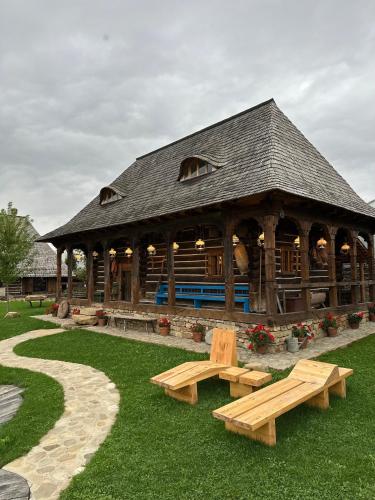 a large wooden pavilion with benches in the grass at Echoes of Vlădicu in Cluj-Napoca