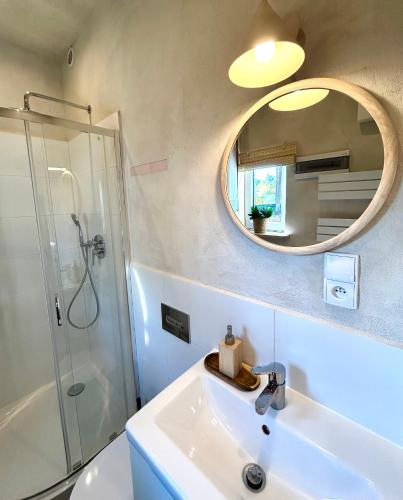 a bathroom with a sink and a mirror at Domek lubiana180 WABI SABI w lesie jacuzzi sauna kominek - drewno w cenie pobytu - nad jeziorem Kaszuby pieski tylko do 10kg za dodatkową opłatą in Łubiana