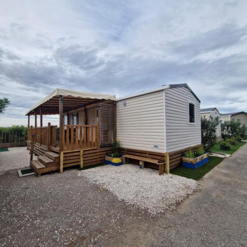 une petite cabine avec une terrasse couverte et une terrasse dans l'établissement Mobil home 6 à 8 personnes SANS Fun Pass, à Canet