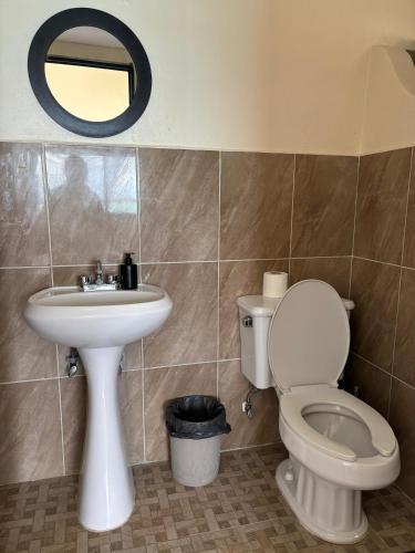 a bathroom with a toilet and a sink and a mirror at Casa Sirena - Habitaciones a orilla de la Laguna y Cenote Esmeralda in Bacalar