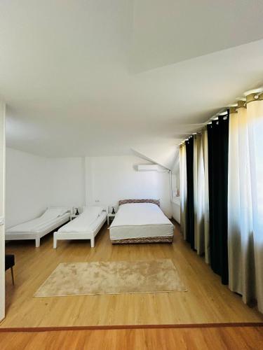 a bedroom with two beds and a wooden floor at Rooms ALEA in Sanski most