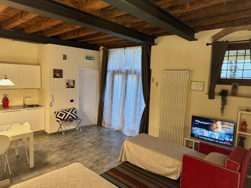 a living room with a bed and a tv and a kitchen at Sciesa24 in Verona