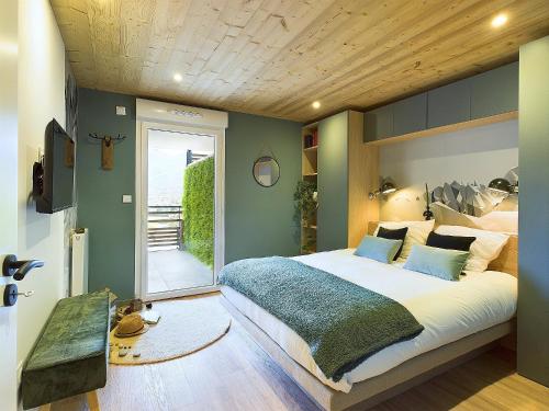 une chambre avec un grand lit avec un plafond en bois dans l'établissement Panorama MontBlanc, à Domancy