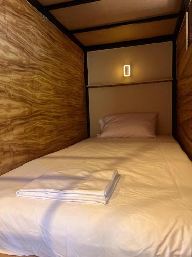 a bed with a white blanket on top of it at Hostal Juárez Puerto Escondido in Brisas de Zicatela