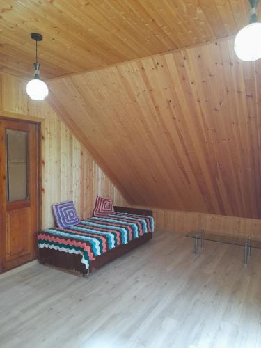 a bed in a room with a wooden ceiling at Myudro agaraki in Bagdatʼi