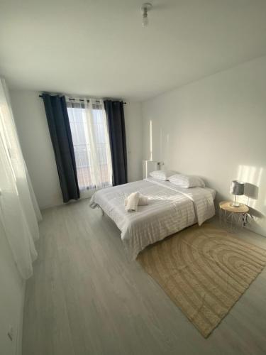 a white bedroom with a bed and a large window at Hébergement proche IMT atlantique ifremer thales le dellec in Plouzané
