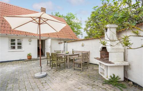 a patio with an umbrella and a table and chairs at 3 Bedroom Amazing Home In Nakskov in Nakskov