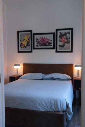 a bedroom with a bed with three pictures on the wall at Vikos Lodge Apartment in Bologna