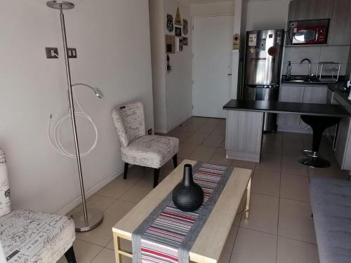 a living room with a table with a vase on it at iquique dos habitaciones vista al mar estacionamiento in Iquique
