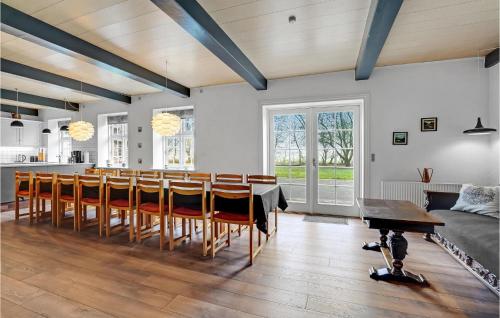 a dining room and kitchen with a table and chairs at Holiday Home Engsvinget Højer X in Vrågård