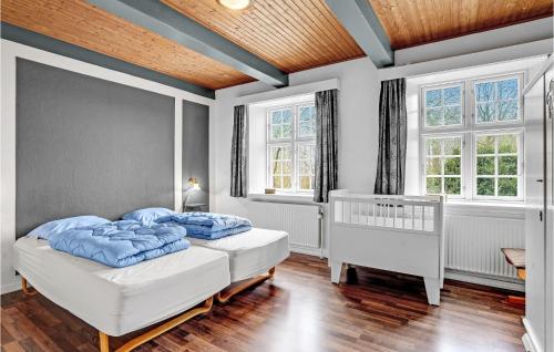 a bedroom with two beds and a crib in it at Holiday Home Engsvinget Højer X in Vrågård