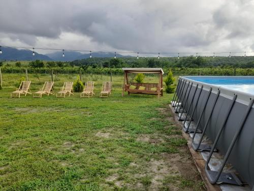 a group of chairs sitting next to a swimming pool at Myudro agaraki in Bagdatʼi
