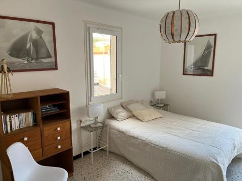 une chambre avec un lit, une chaise et une fenêtre dans l'établissement Banyuls vu d'en haut : appartement T3 spacieux, à Banyuls-sur-Mer