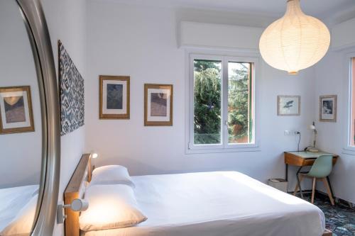 una camera da letto bianca con un letto e una finestra di Casa DiMondi a Bologna