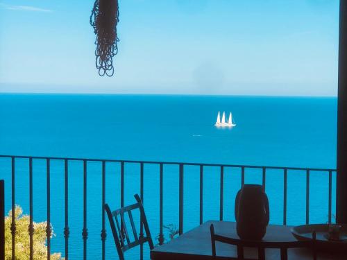 Cette chambre dispose d'un balcon avec un bateau dans l'océan. dans l'établissement Belle Villa VUE MER EXCEPTIONNELLE PISCINE PRIVÉE 3 mn PLAGES et CALANQUES, à Anthéor