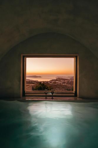 a room with a window looking out at the sunset at Aethra Vegan Caves in Pirgos