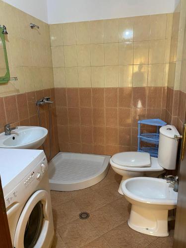 un bagno con due WC, un lavandino e una lavatrice di Seaside Bliss 3 a Golem