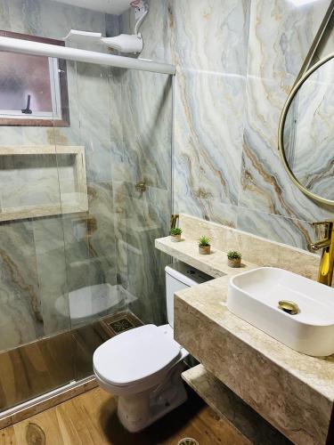 a bathroom with a toilet and a sink and a shower at RAIO DE LUZ GUARAPARI BEACH in Guarapari