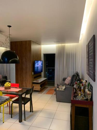 a living room with a couch and a table at Apartamento completo no Guarujá in Guarujá