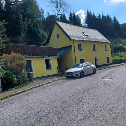 a car parked in front of a yellow house at Ferienhaus Benko in Hieflau