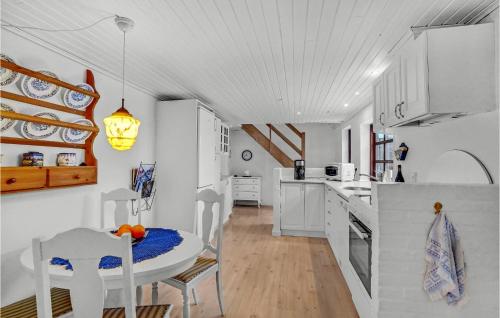 a kitchen with white cabinets and a table and chairs at Lovely Home In Hurup Thy With Wifi in Gettrup