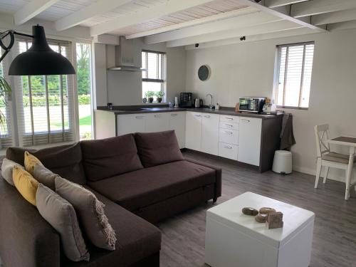 a living room with a couch and a kitchen at Heitse B&B en vakantiewoning in Heythuysen